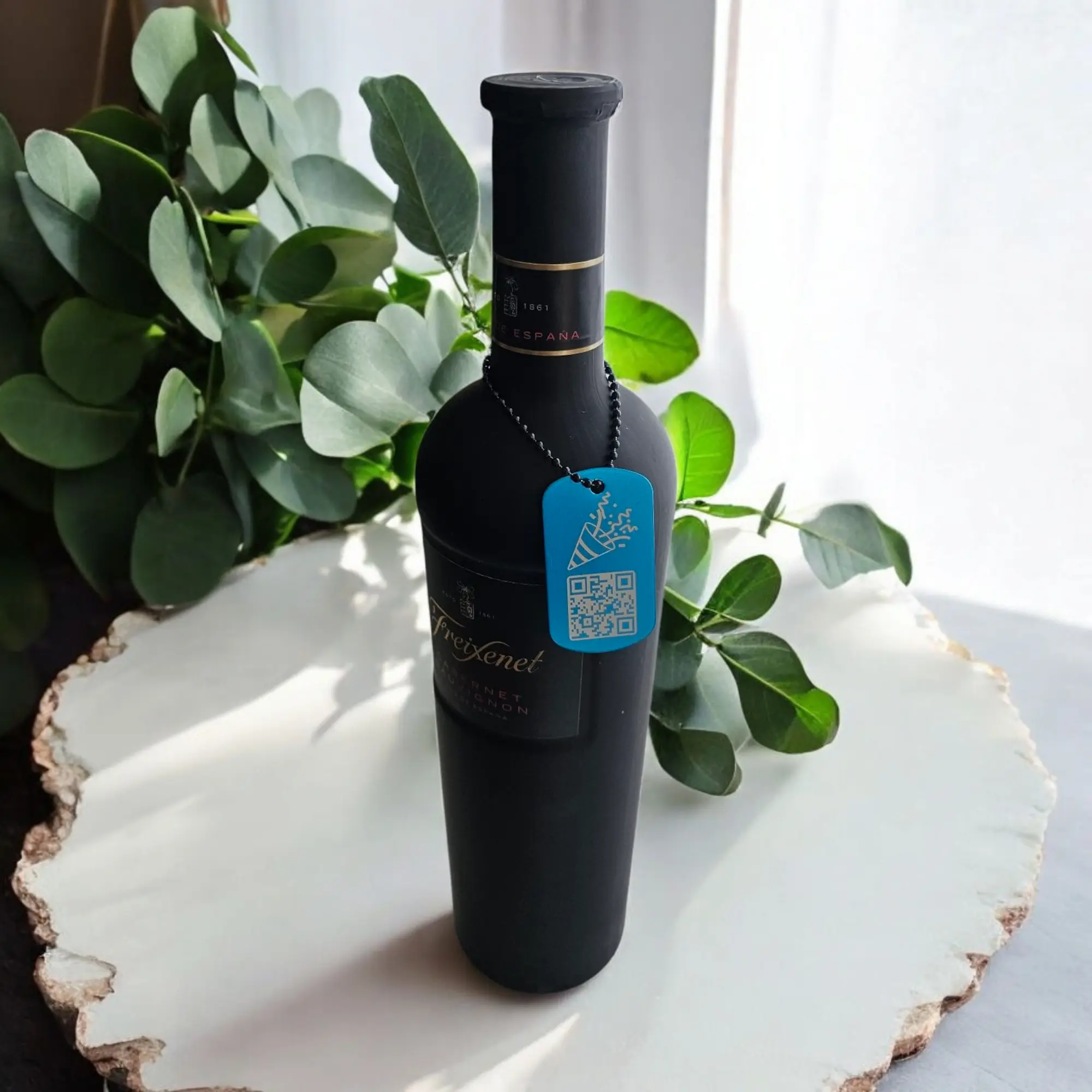 Blauer Party Popper QR-Anhänger als originelles Geschenk-Etikett an einer Weinflasche – für personalisierte Grußbotschaften.