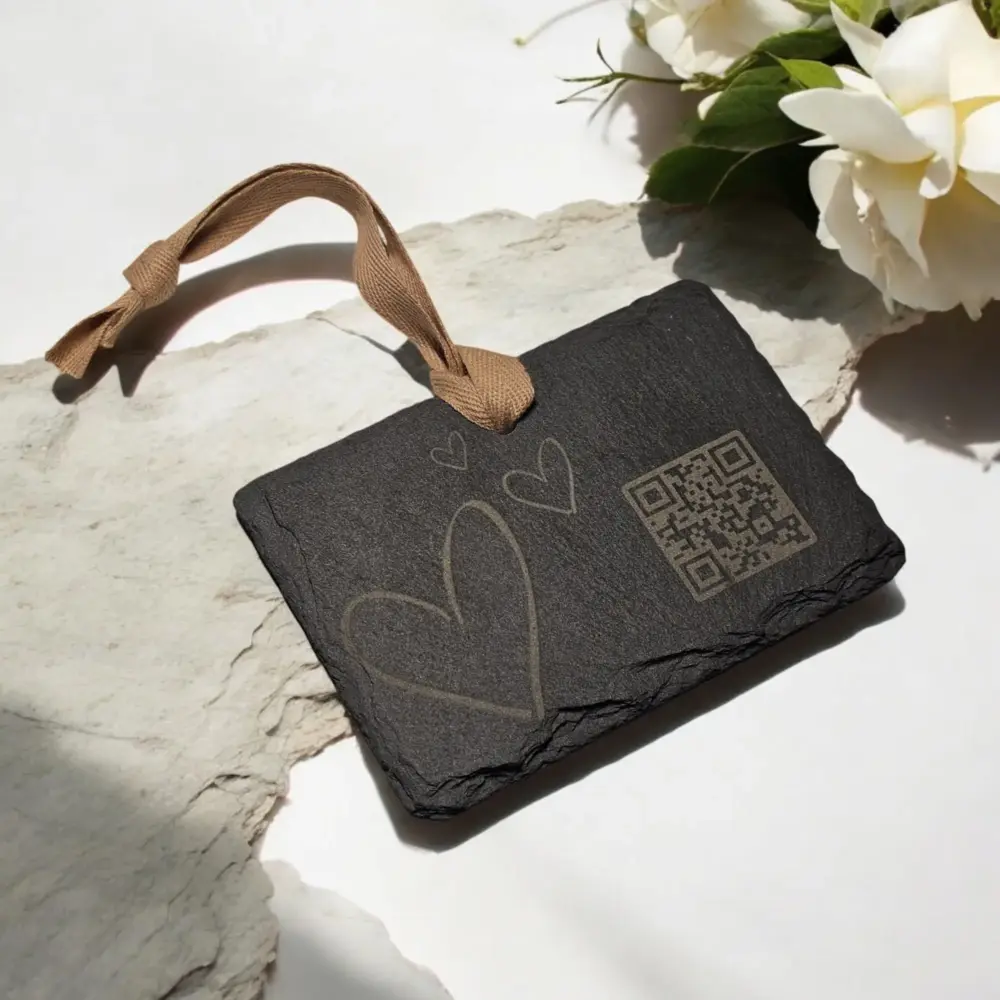Schwarzer Schieferanhänger mit Herzgravur und QR-Code, dekorativ mit weißer Rose – ideal für individuelle Grüße