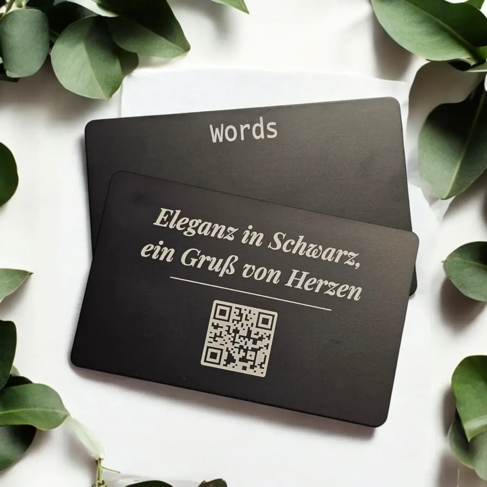 Schwarze Metallkarten mit filigraner Gravur und integriertem QR-Code für persönliche digitale Nachrichten
